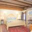 Interior photo of a classically decorated room with an exposed rafter beam ceiling and brick fireplace