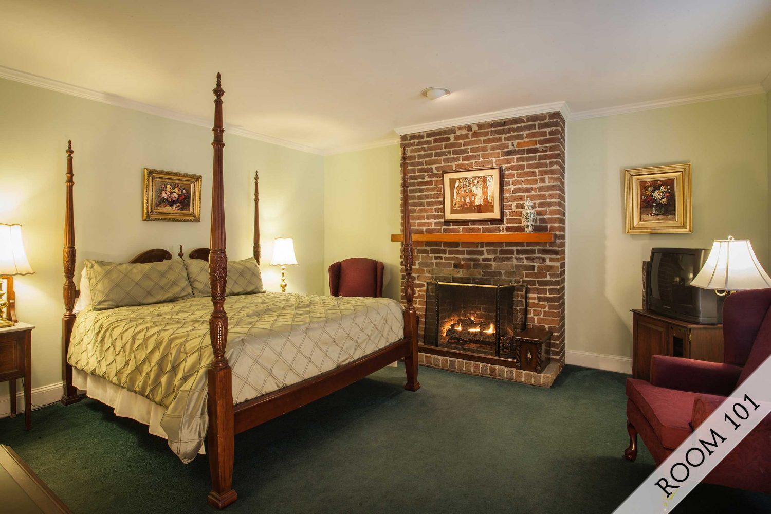 Interior photo of a classically decorated room with an exposed rafter beam ceiling and brick fireplace