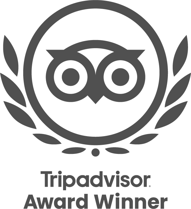A dark grey logo featuring the Tripadvisor owl mascot inside a laurel wreath, with text reading "Tripadvisor Award Winner".