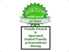 A green and white logo with the words east hills inn & suites.