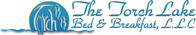 Logo for "The Torch Lake Bed & Breakfast, LLC" in blue, featuring stylized water waves and a circular design on the left with the word "Torch" inside, highlighting this charming bed and breakfast by Torch Lake.